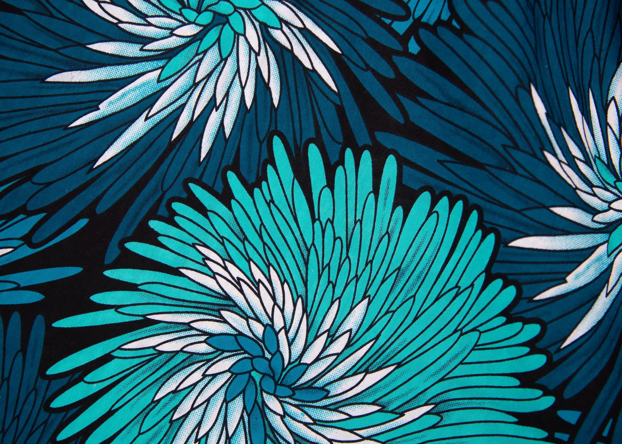 Close up display of turquoise, black, pacific blue, slate and white feathered spiral print dress
