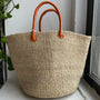 Natural woven sisal basket with leather handle.