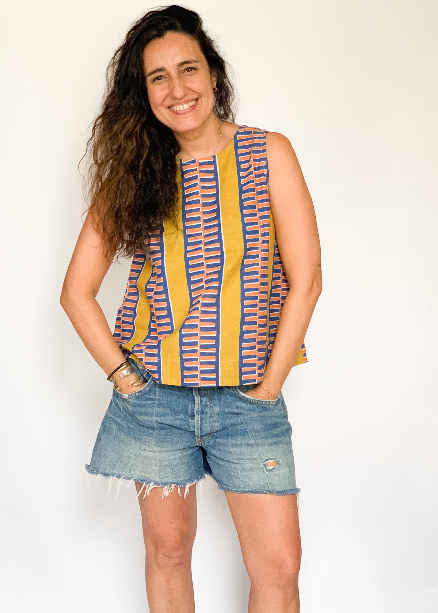 The model is wearing olive-yellow, blue, orange and white geometric printed  tank