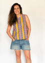 The model is wearing olive-yellow, blue, orange and white geometric printed tank