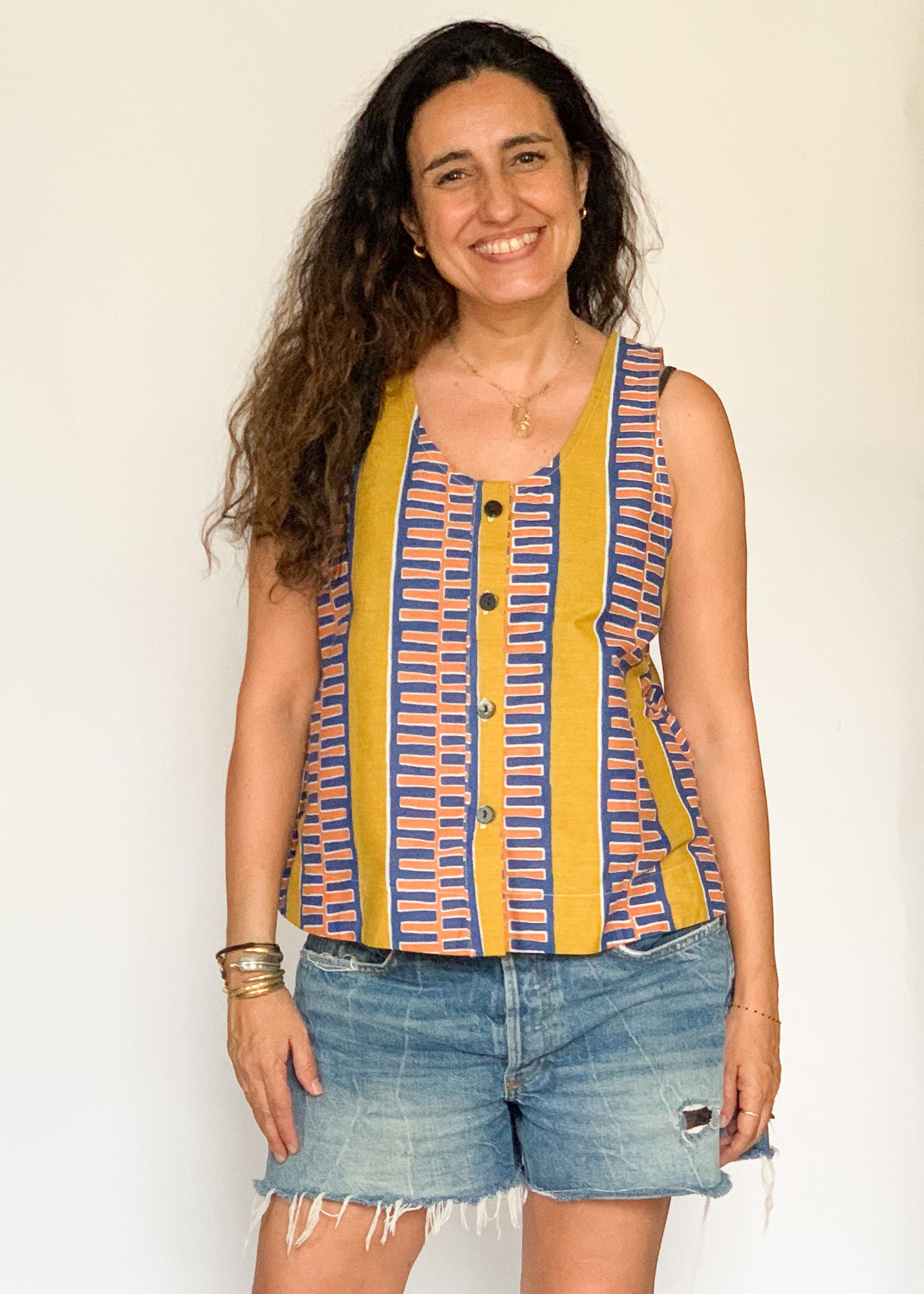 The model is wearing olive-yellow, blue, orange and white geometric printed  tank