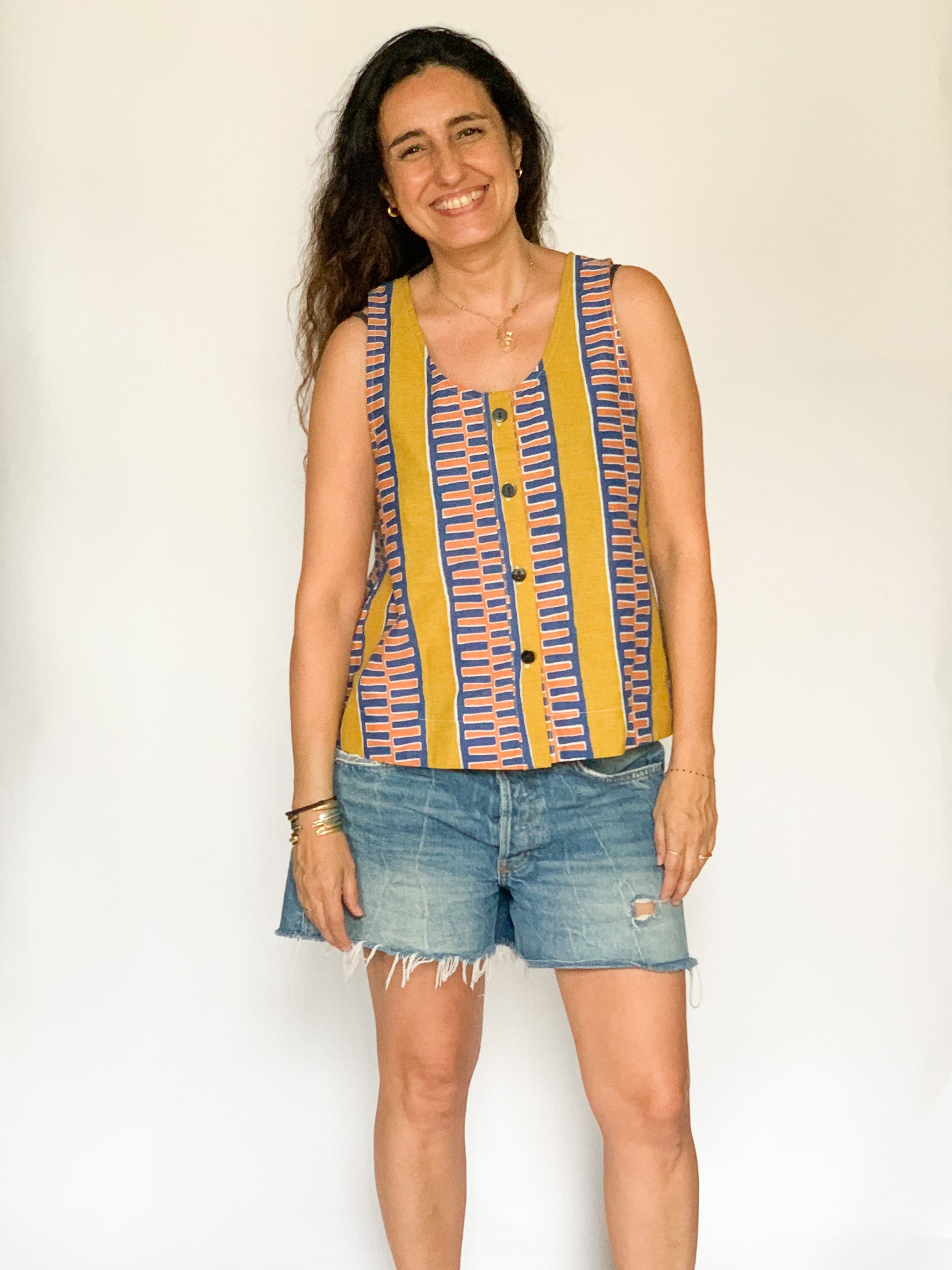 The model is wearing olive-yellow, blue, orange and white geometric printed  tank