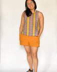 The model is wearing olive-yellow, blue, orange and white geometric printed  tank