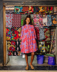 The model is wearing violet dress with red and white cabbages