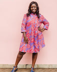 The model is wearing violet dress with red and white cabbages