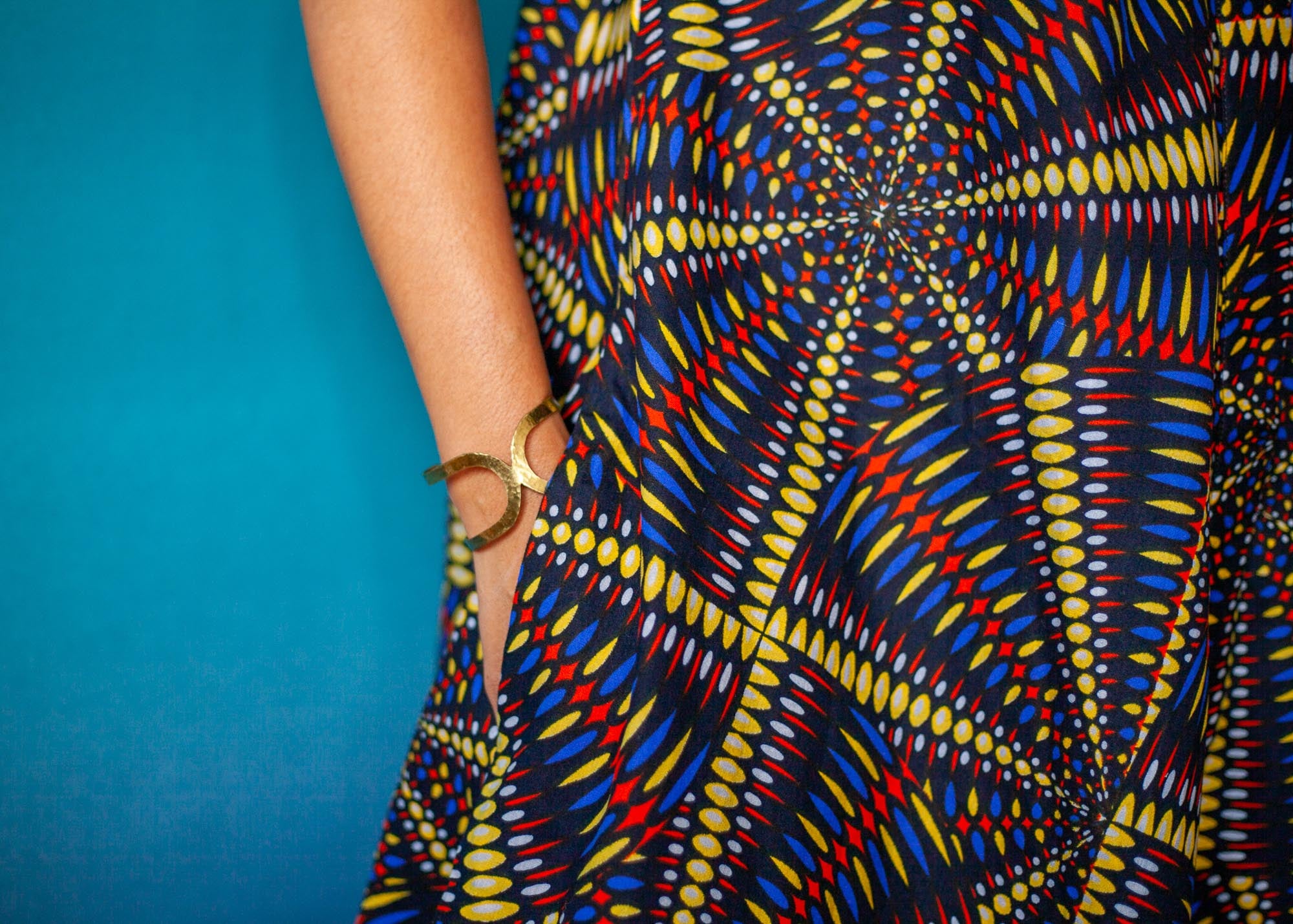 The model is wearing multi-colored abstract print dress