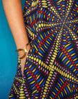 The model is wearing multi-colored abstract print dress