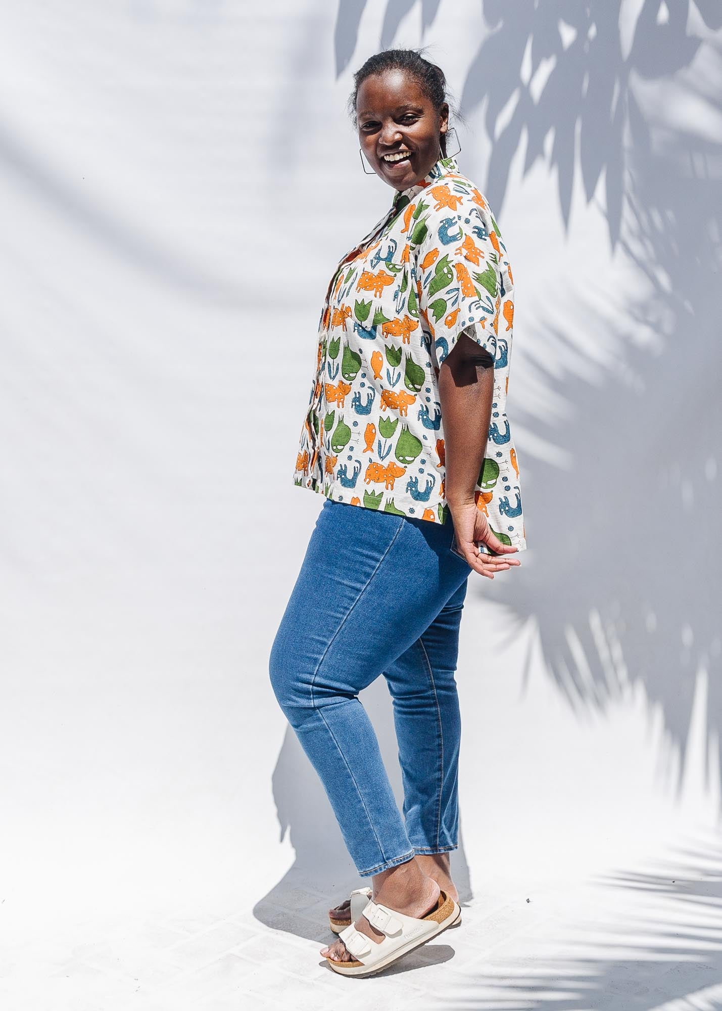 The model is wearing blue, orange, green, brown, white and black print shirt