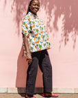 The model is wearing blue, orange, green, brown, white and black print shirt