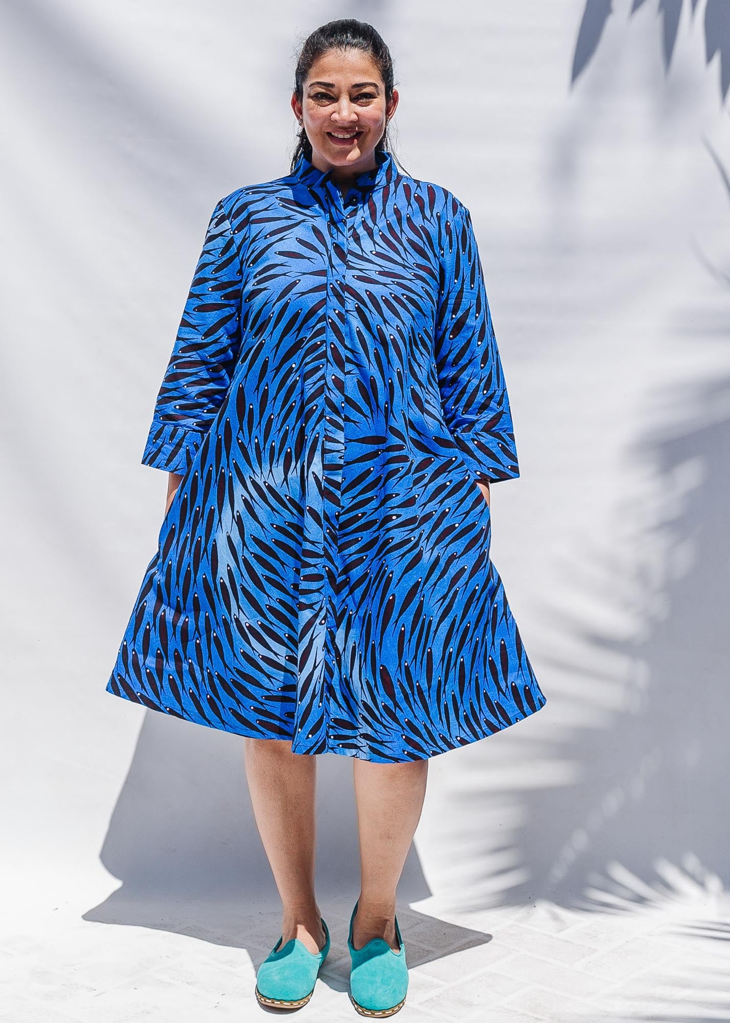 The model is wearing dark-red, blue and white baby shark printed dress