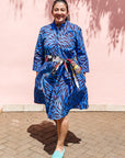 The model is wearing dark-red, blue and white baby shark printed dress