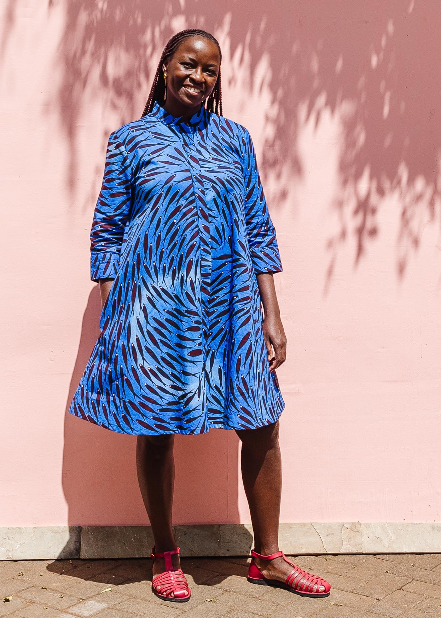 The model is wearing dark-red, blue and white baby shark printed dress