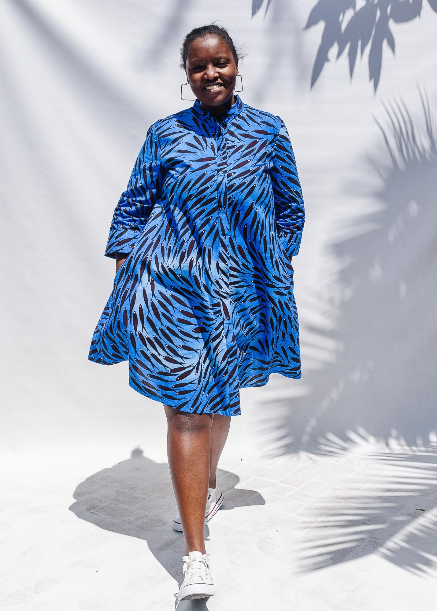 The model is wearing  dark-red, blue and white baby shark printed dress