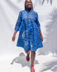 The model is wearing dark-red, blue and white baby shark printed dress