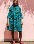  The model is wearing black, blue,  green print dress 