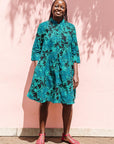  The model is wearing black, blue,  green print dress 