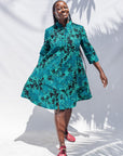  The model is wearing black, blue,  green print dress 