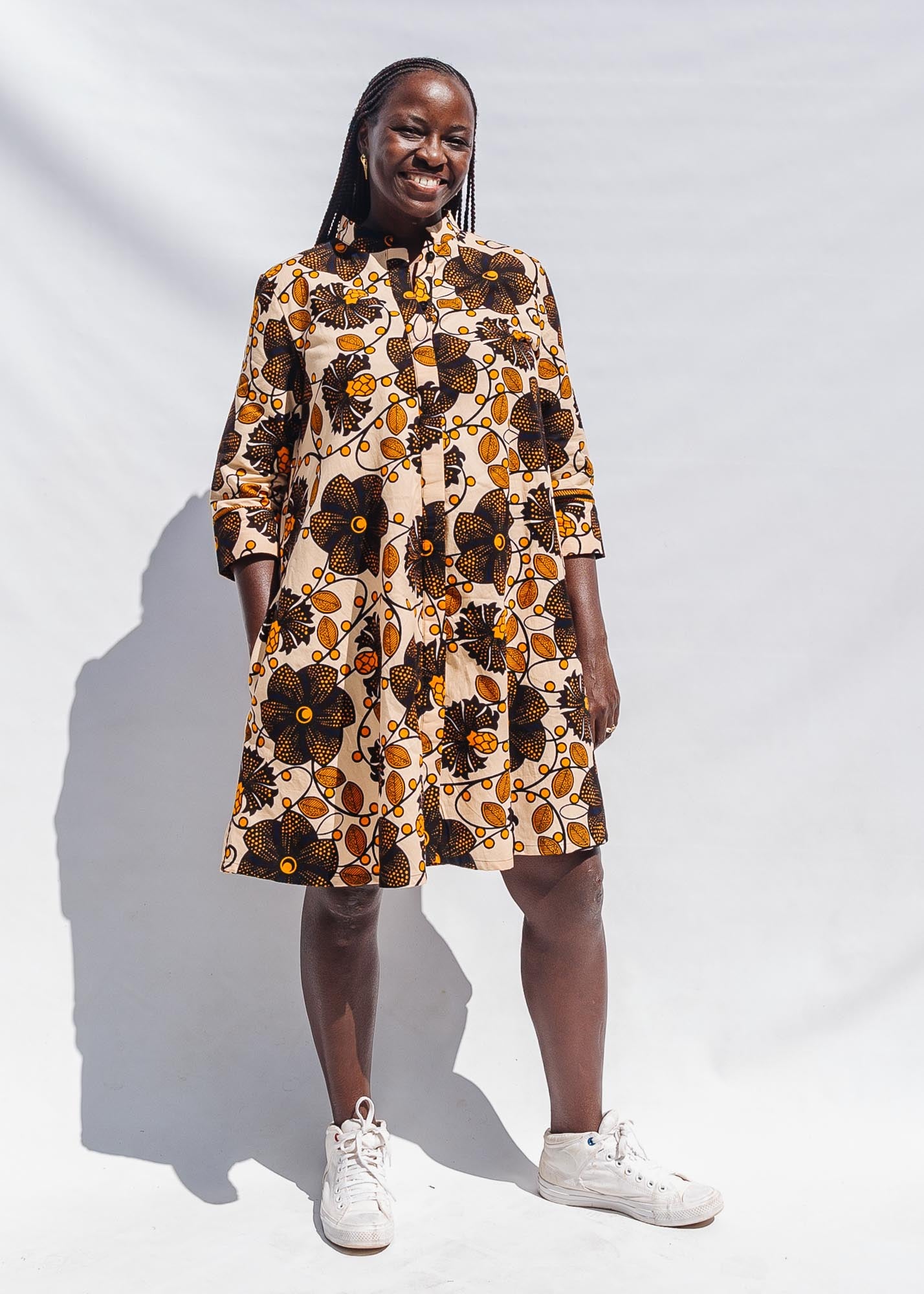 The model is wearing navy, black, off white, yellow flower print dress 