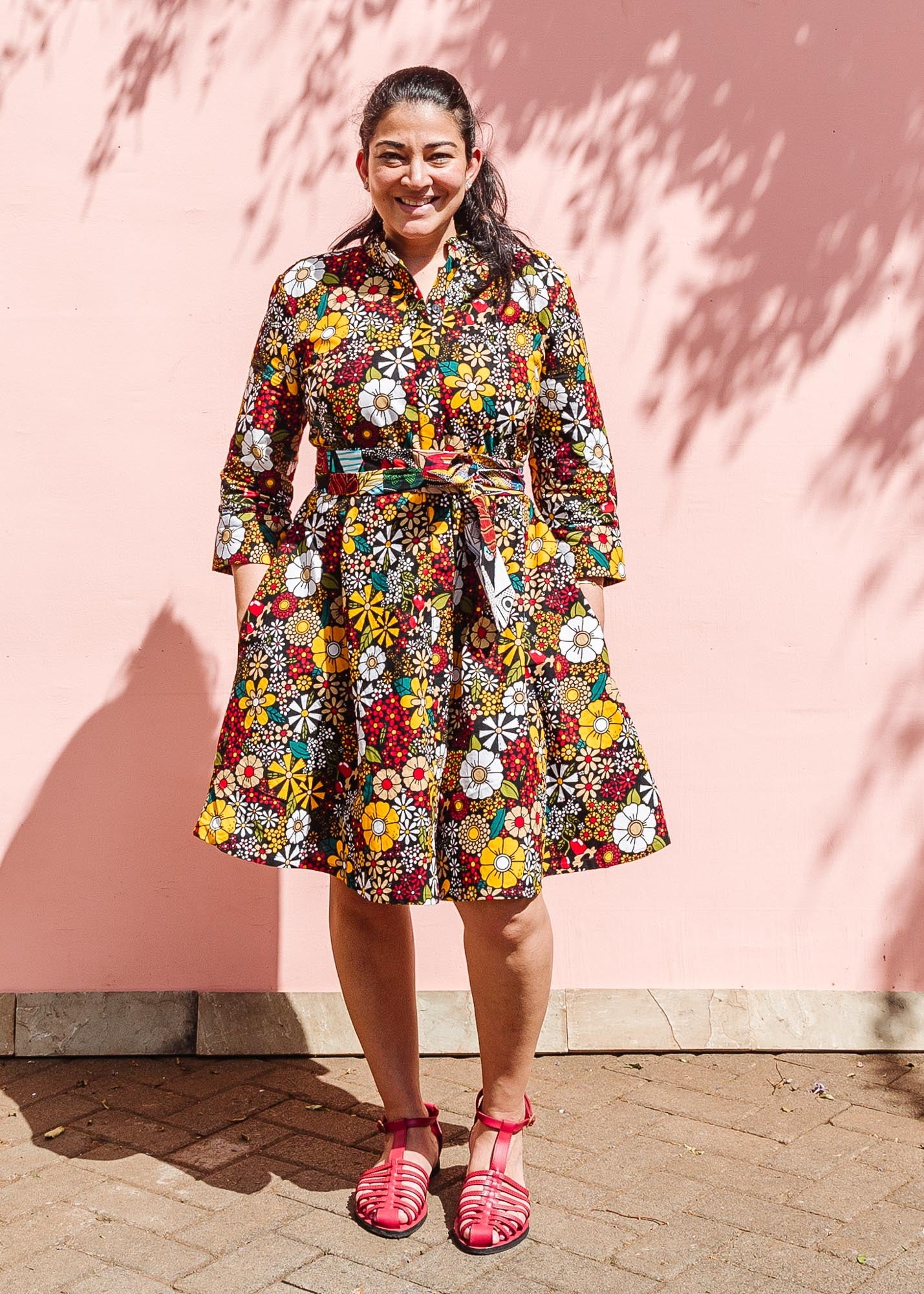 The model is wearing colorful flower print dress