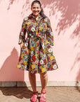 The model is wearing colorful flower print dress