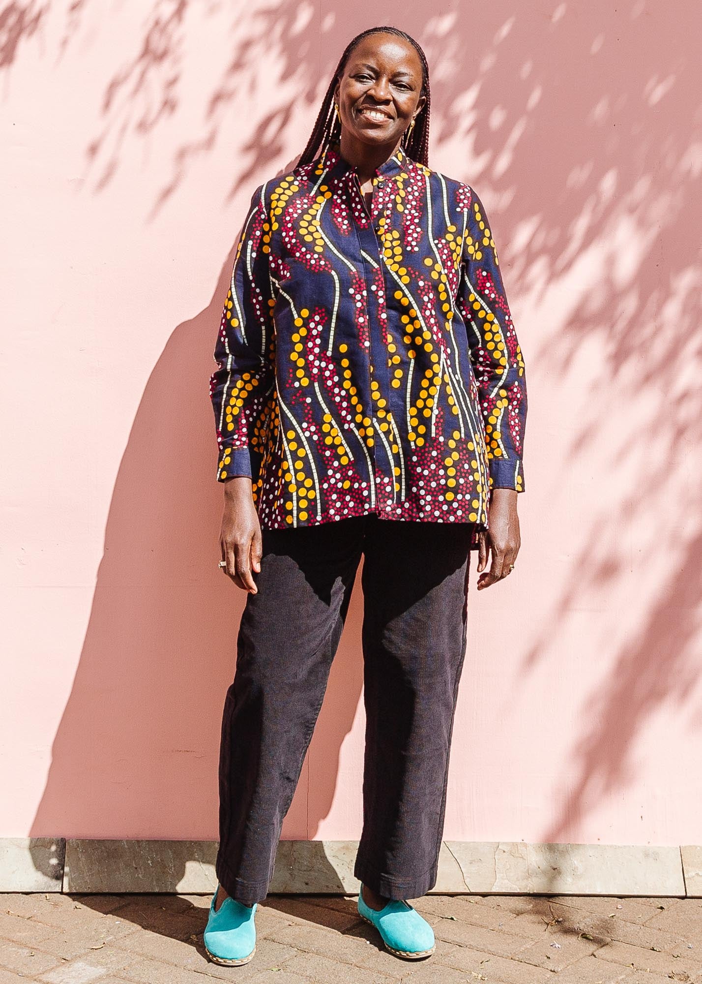  The model is wearing navy, yellow, white, red print shirt