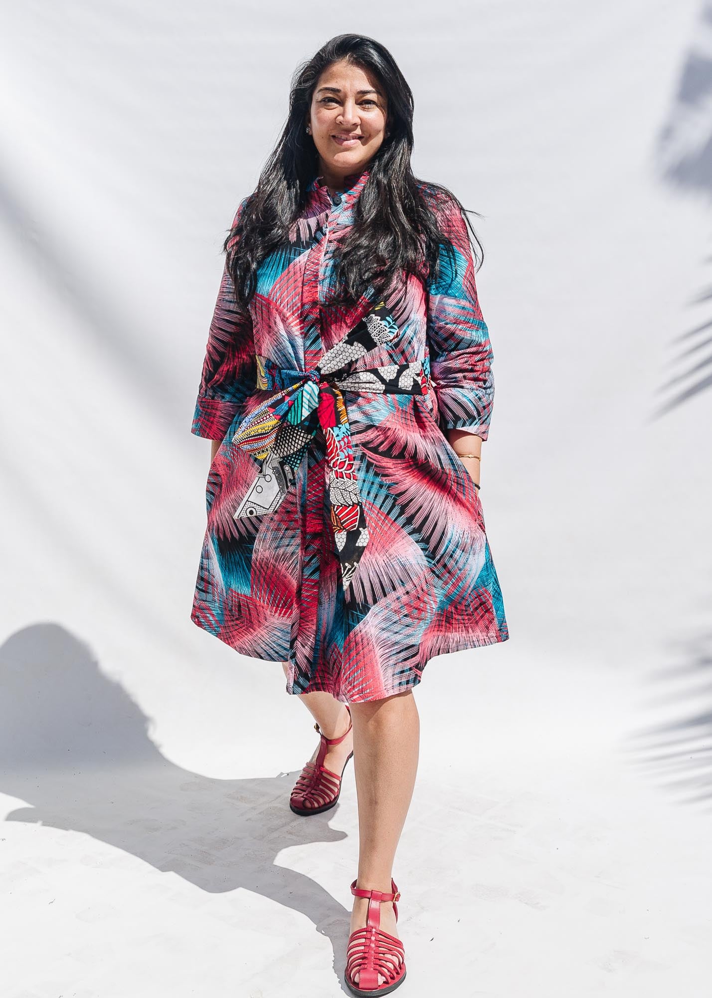 The model is wearing black, red, pink, light blue print dress