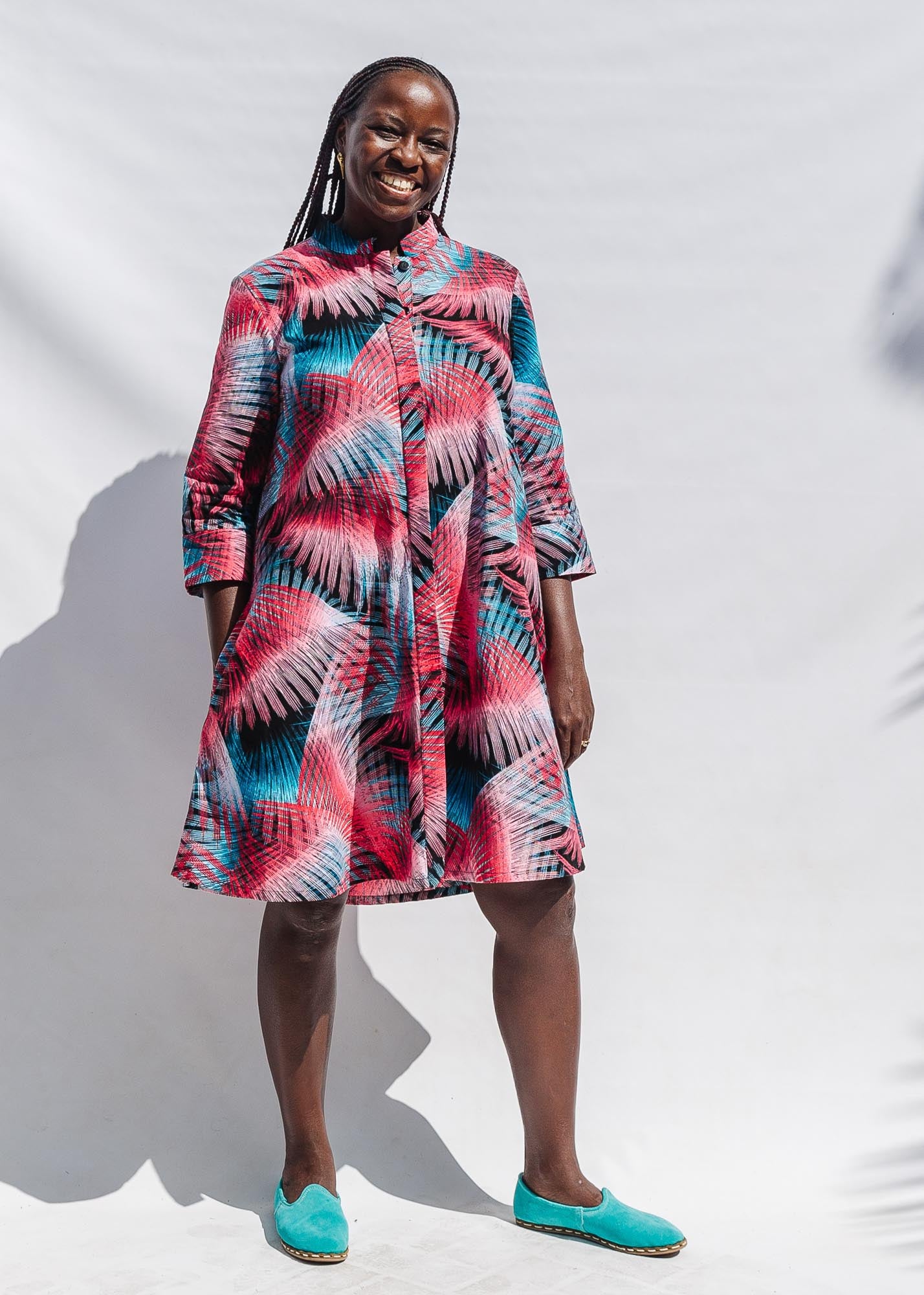 The model is wearing black, red, pink, light blue print dress