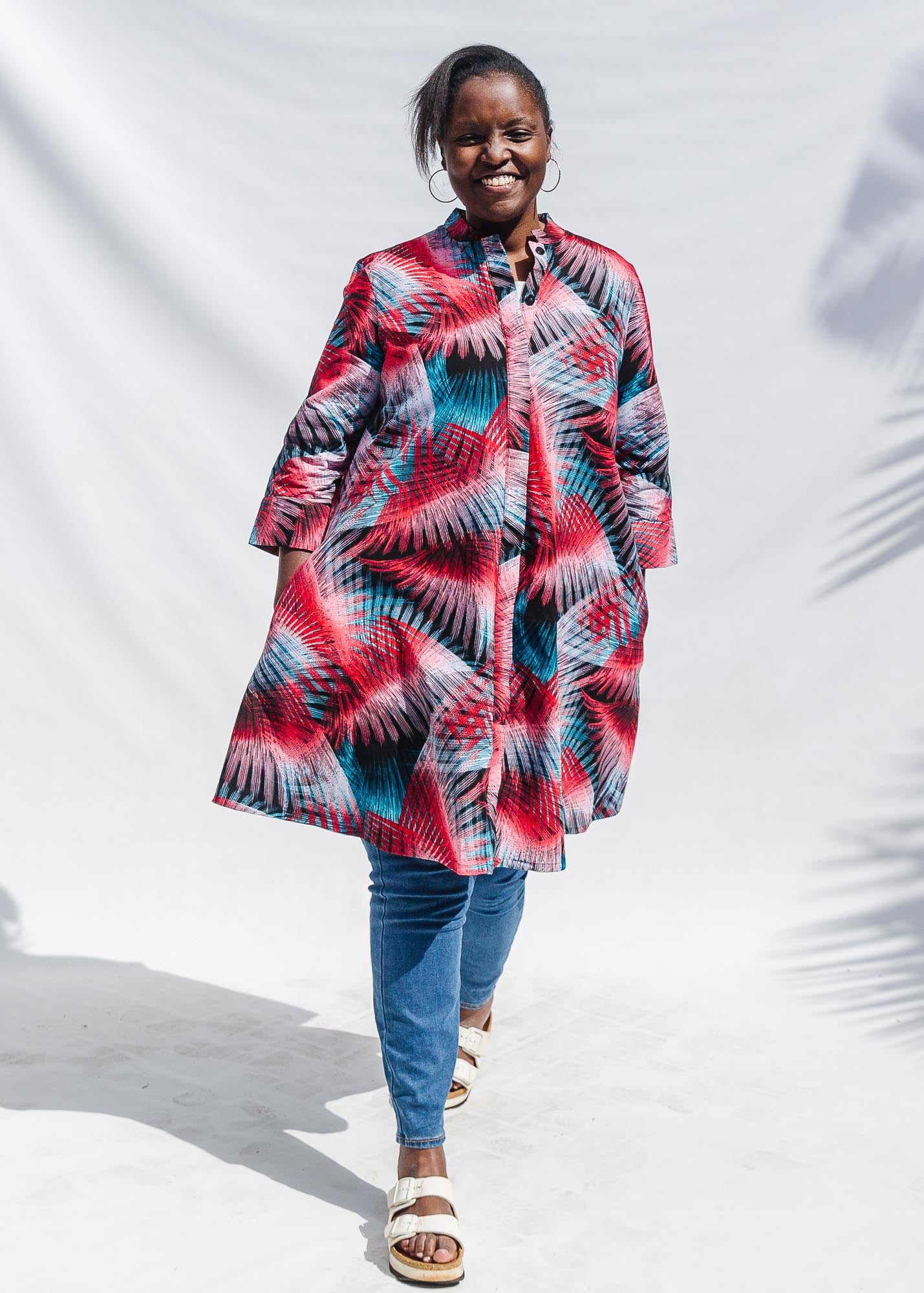 The model is wearing black, red, pink, light blue print dress