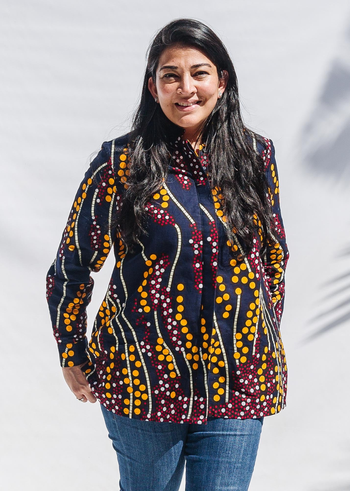  The model is wearing navy, yellow, white, red print shirt