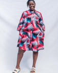 The model is wearing black, red, pink, light blue print dress