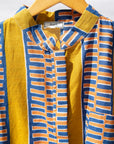 Display of olive-yellow, blue, orange and white geometric printed shirt