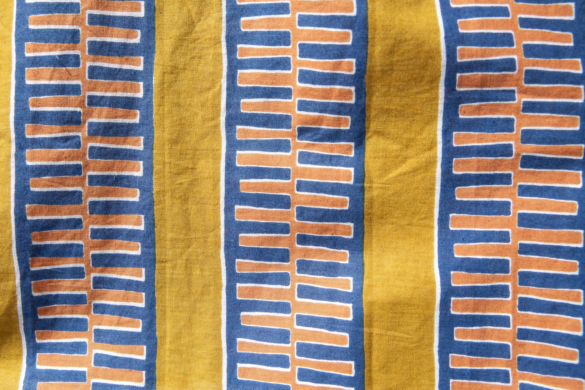 Close up display olive-yellow, blue, orange and white geometric printed shorts