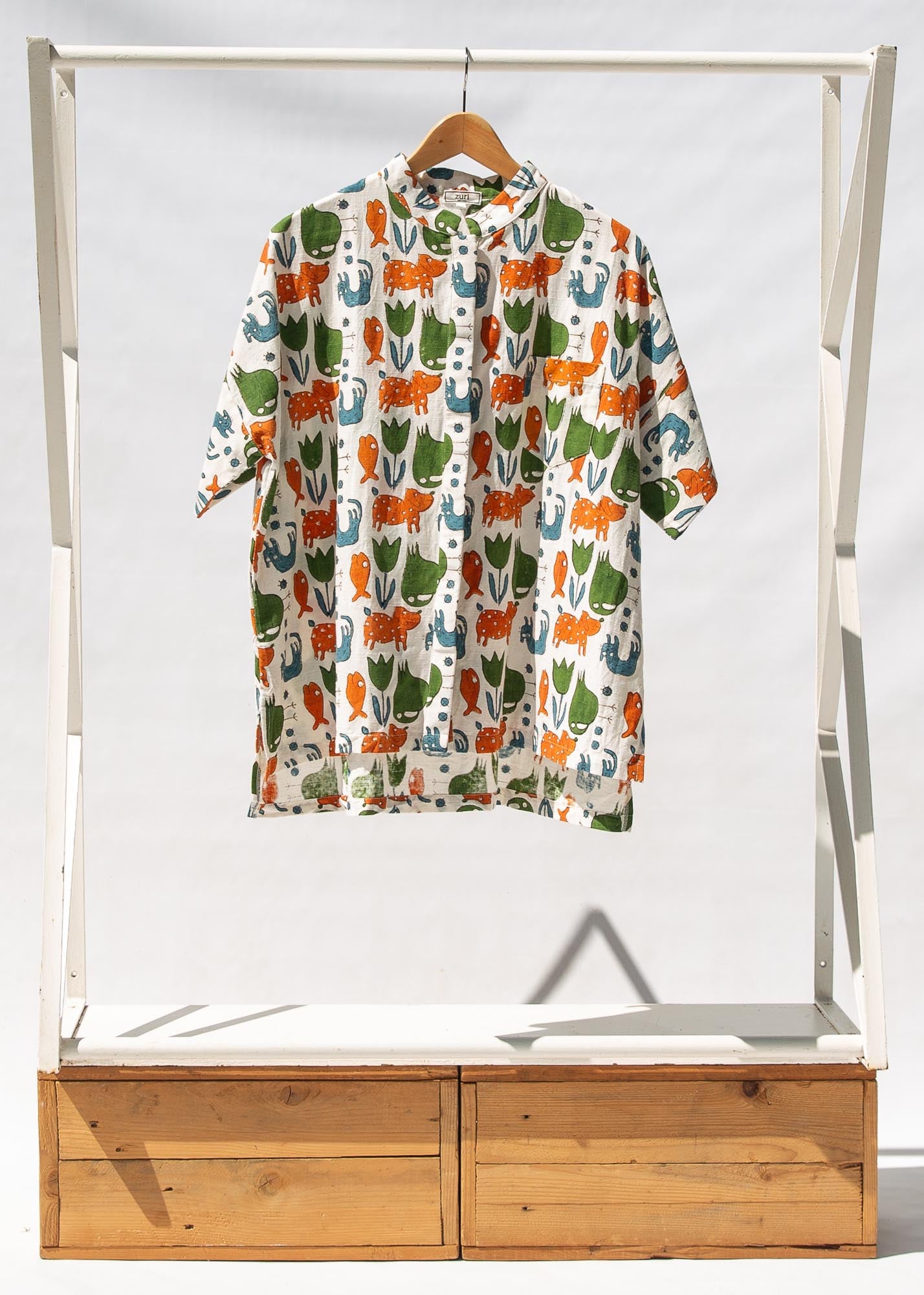 Display of blue, orange, green, brown, white and black print shirt