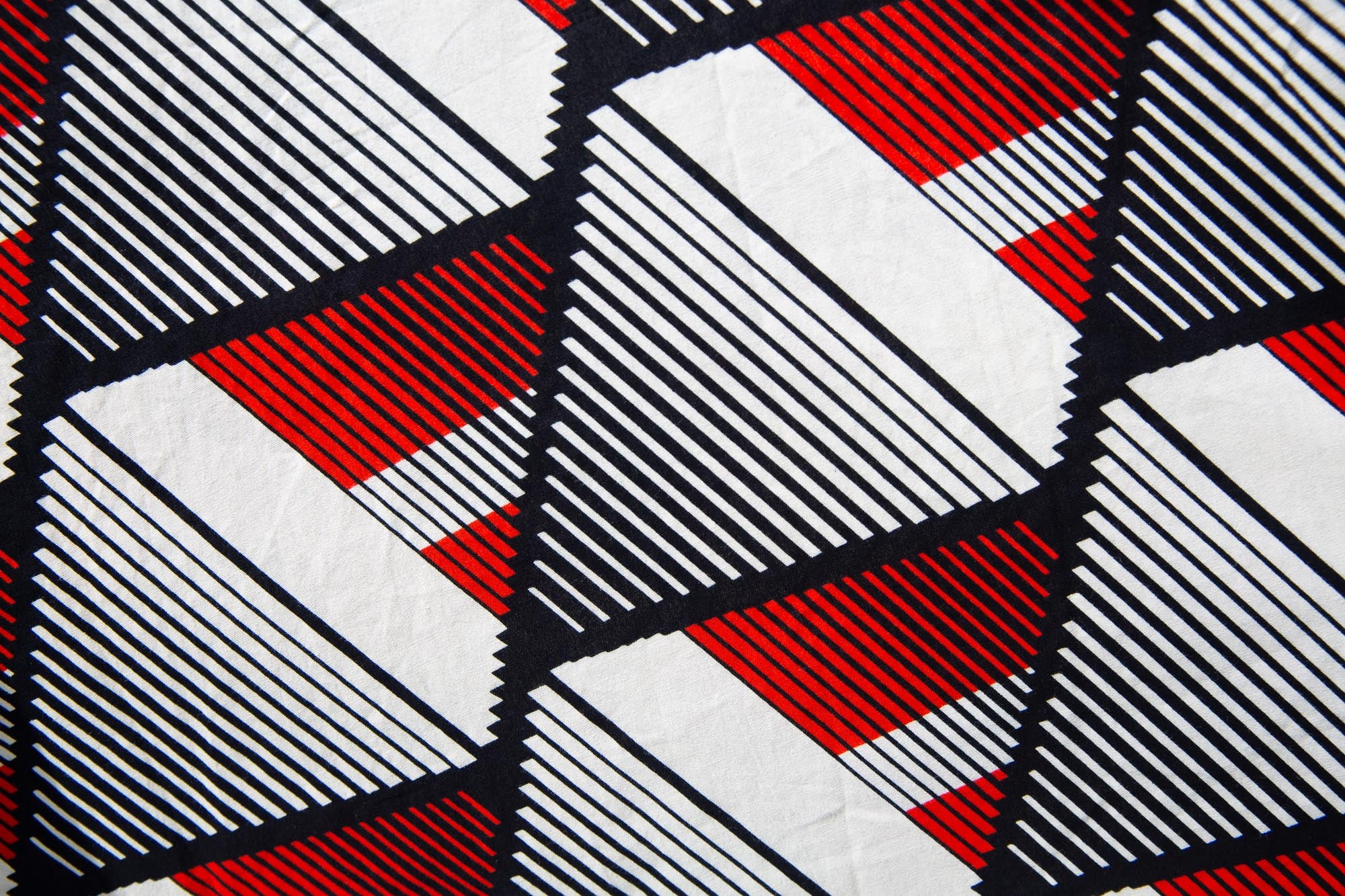 Close up display of black, red, off white print dress