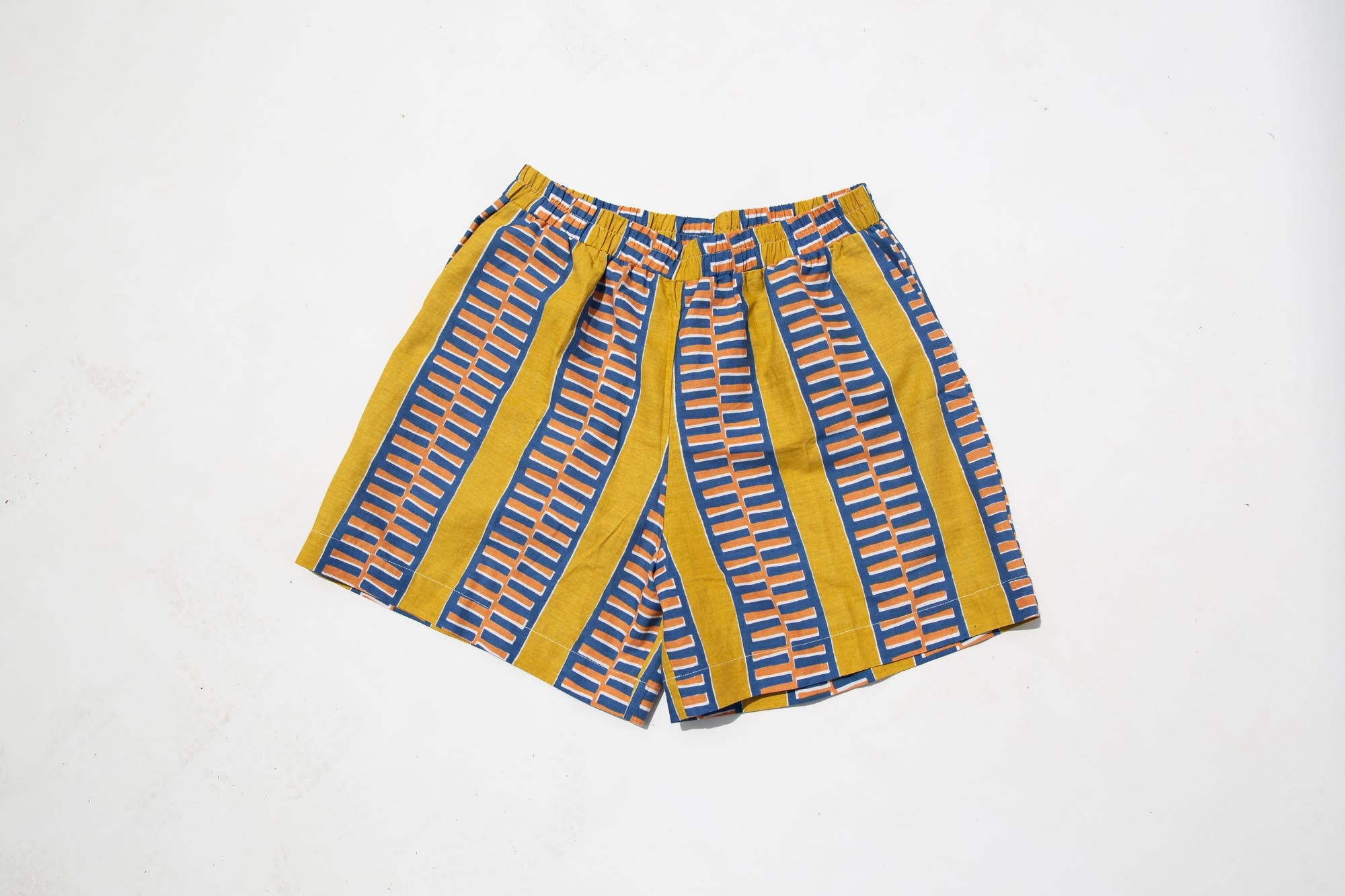 Display of olive-yellow, blue, orange and white geometric printed shorts