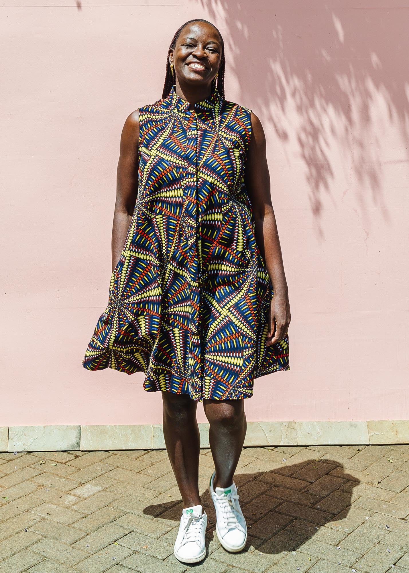 The model is wearing multi-colored abstract print dress