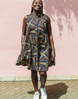 The model is wearing multi-colored abstract print dress