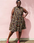 The model is wearing multi-colored abstract print dress