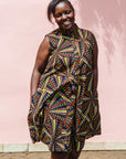 The model is wearing multi-colored abstract print dress