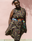 The model is wearing multi-colored abstract print dress