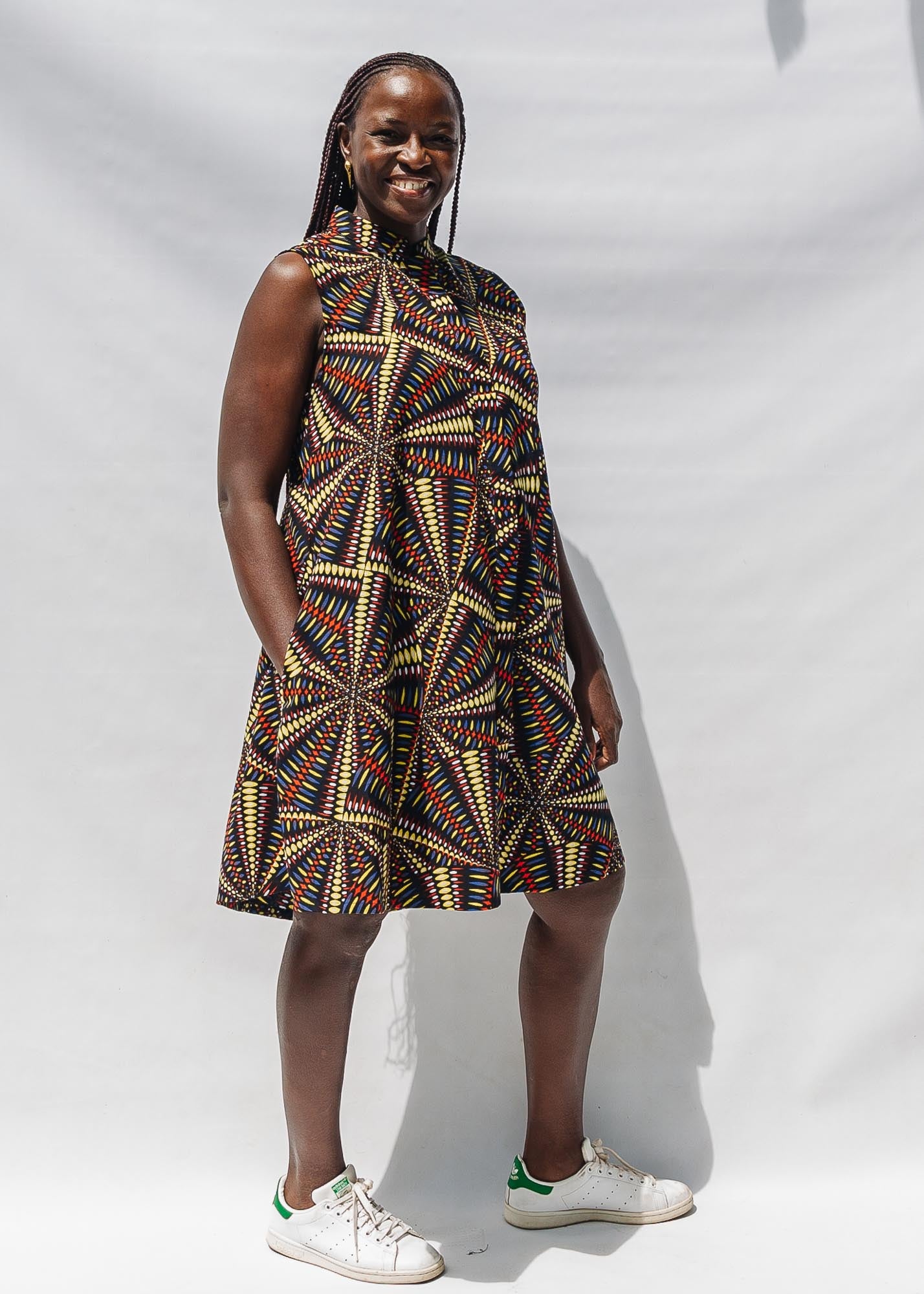 The model is wearing multi-colored abstract print dress