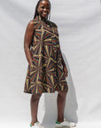 The model is wearing multi-colored abstract print dress