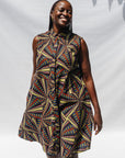 The model is wearing multi-colored abstract print dress