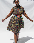 The model is wearing multi-colored abstract print dress