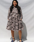 The model is wearing black, off white, gray and dark gray abstract print dress