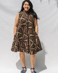 The model is wearing multi-colored abstract print dress