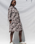 The model is wearing black, off white, gray and dark gray abstract print dress