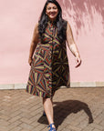 The model is wearing multi-colored abstract print dress