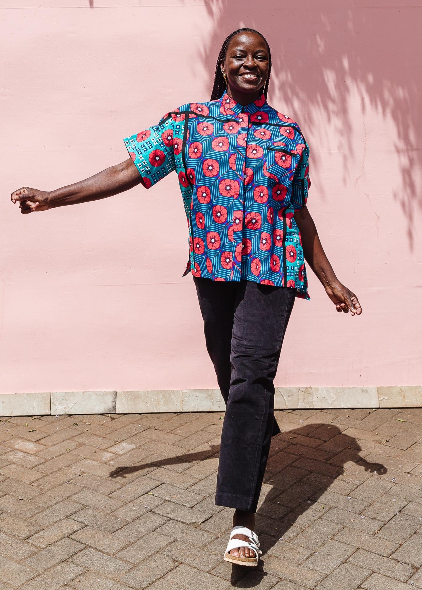 The model is wearing blue, pink, turquoise, black and white mixed pattern floral print shirt