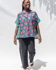 The model is wearing blue, pink, turquoise, black and white mixed pattern floral print shirt